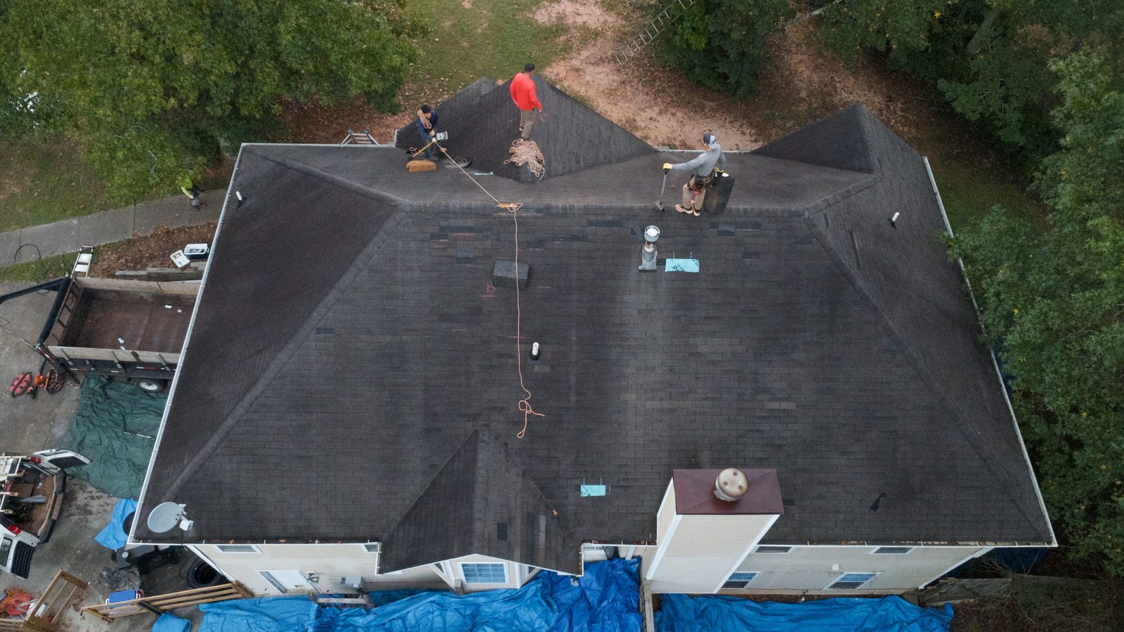 Before: aerial view of the worn original roof as the crew begins the tear-off